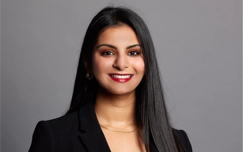 Ahana Banerjee - an Asian woman with long black hair, smiling at the camera.