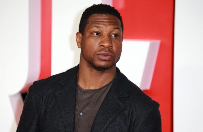 Jonathan Majors and Meagan Good hold hands as he appears in court
