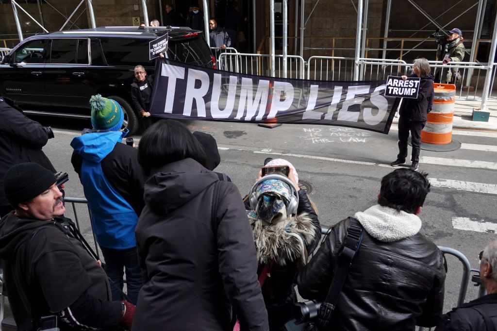 Demonstrators hold a banner in front a group of journalists