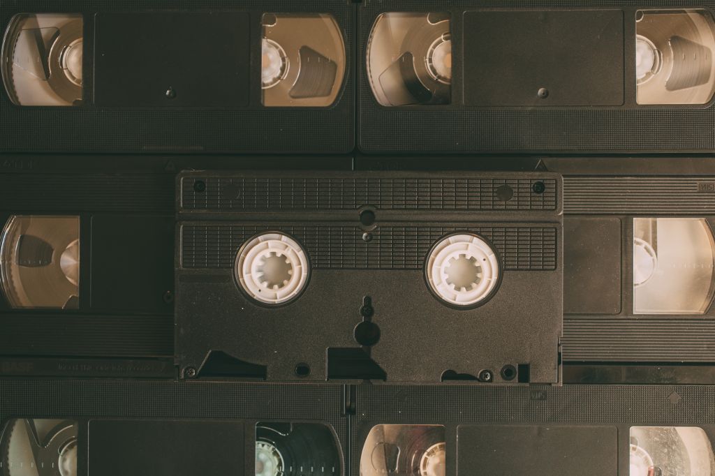 Stack of VHS video tapes as background. Old video cassette tapes. Retro technology. - stock photo