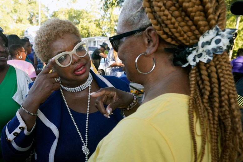 Ju'Coby Pittman, left, a Jacksonville city councilwoman, talks with supporters at a prayer vigil for the victims of Saturday's mass shooting Sunday.