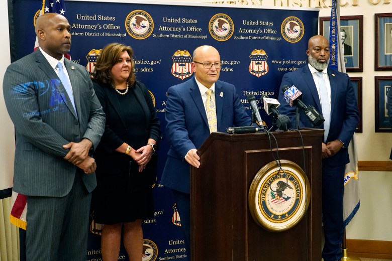 U.S. Attorney Darren J. LaMarca, center, speaks to reporters after six white former law enforcement officers in Mississippi pleaded guilty to federal civil rights offenses in federal court in Jackson, Miss.