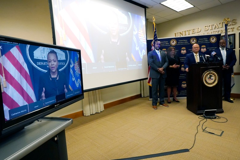 Assistant Attorney General for Civil Rights at the U.S. Department of Justice, Kristen Clarke, left, addresses reporters from a monitor during a news conference following a court hearing where six white former Mississippi law enforcement officers plead guilty to federal civil rights offenses in federal court, in Jackson, Miss.