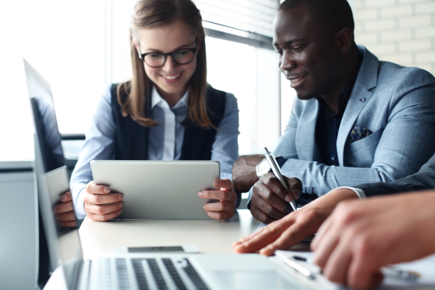 Image shows Black business man and white business woman at a meeting