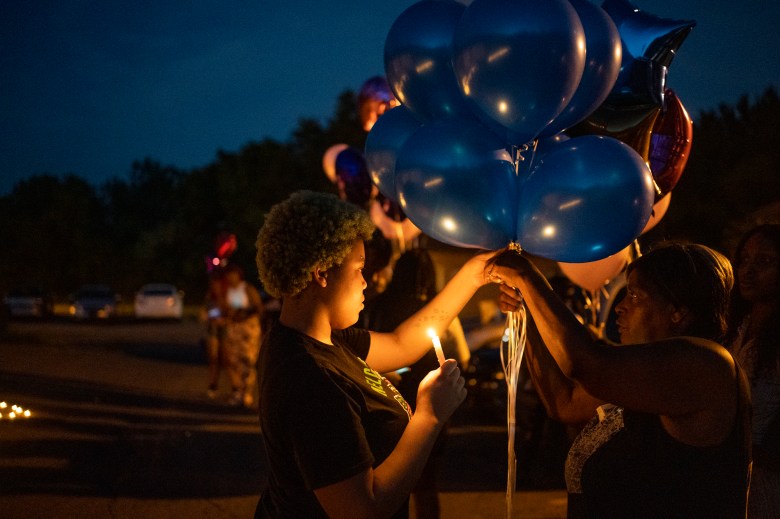 Nadine Young, right, the grandmother of Ta'Kiya Young, gathers with family and friends during a candlelight vigil .