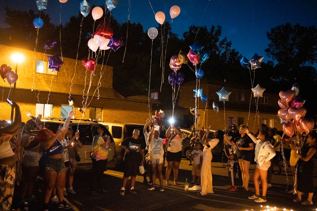 Family and friends release balloons at a private vigil.