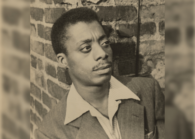 James Baldwin poses on a rooftop.