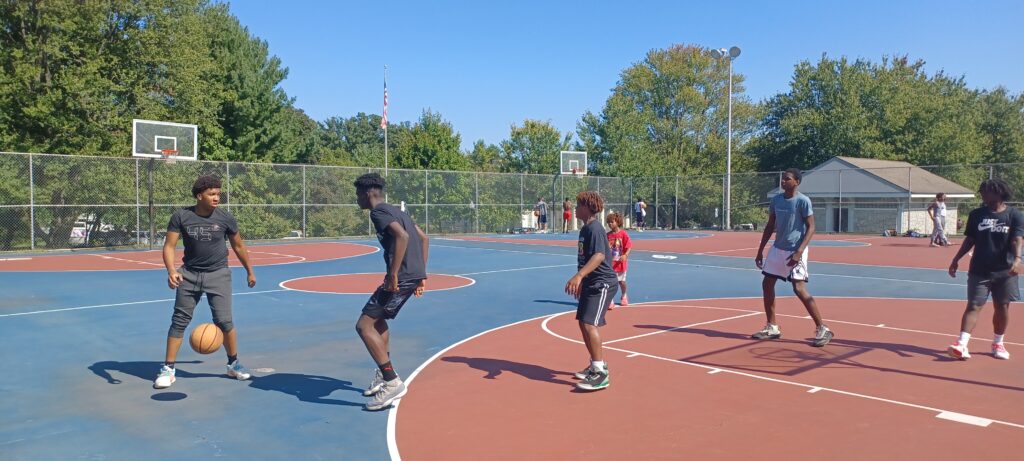 Anthony Michael Hobbs (left), founder of the Imagination Lunchbox International Children's Film Fest, playing ball with local youth at the ILICFF Basketball Tournament.