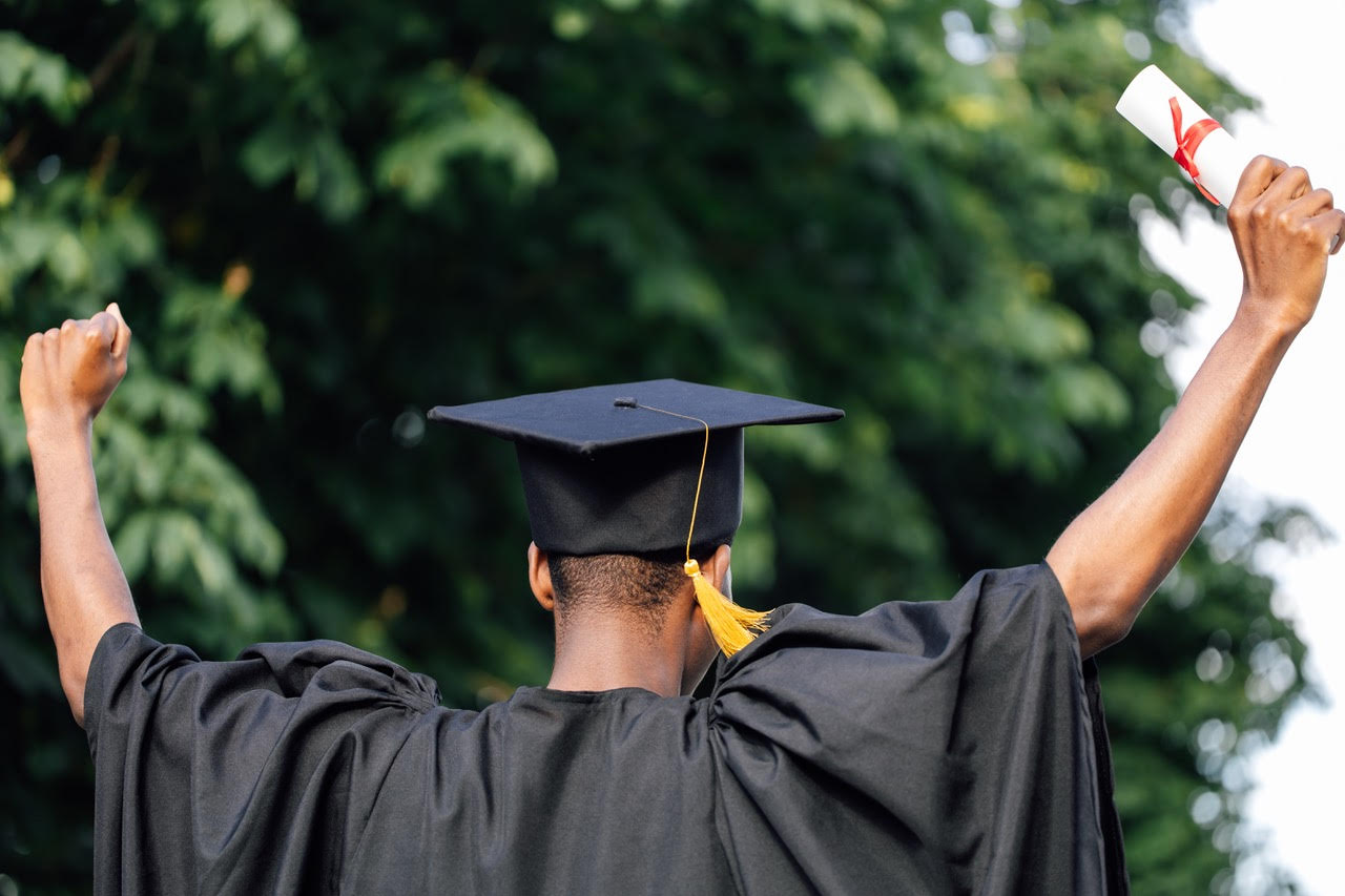 Black college graduate celebrating