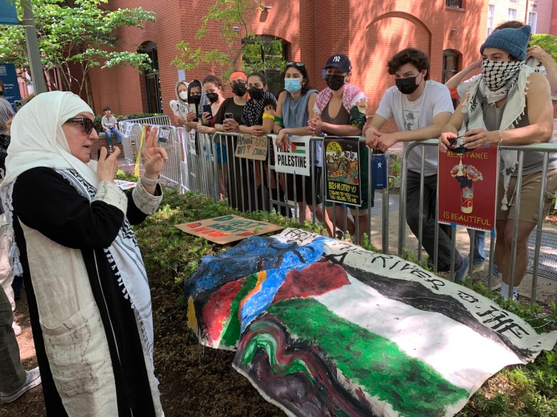 Haifaa Younis, an OB/GYN who visited the encampment April 28 to share the harrowing story of eight days she spent working in a hospital in Gaza earlier this month, speaks with students inside the encampment. (Kayla Benjamin/The Washington Informer)