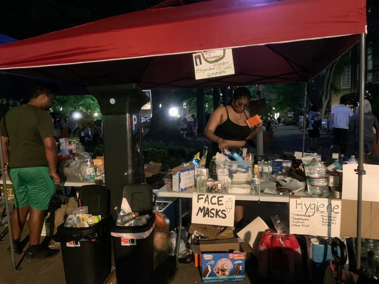 GWU students do one last check of the encampment’s supply tables late on April 29. (Kayla Benjamin/The Washington Informer)