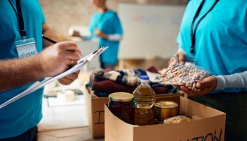 Close up of volunteers packing boxes at donation center.